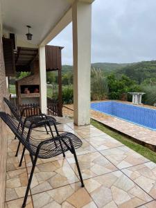 a patio with two chairs and a swimming pool at Casa refúgio in Santana do Livramento