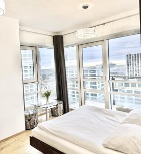 a bedroom with a bed and large windows at Platinum Towers Country 2 Country in Warsaw