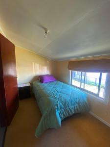 1 dormitorio con cama y ventana en Calor y amor de hogar chilote en Castro