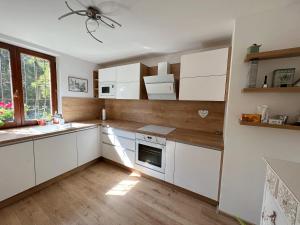 a kitchen with white cabinets and a window at Apartmán Stará Sásová in Banská Bystrica