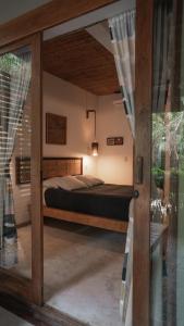 1 dormitorio con 1 cama y puerta de cristal en Griss Lodge & Villas, en Santa Teresa Beach