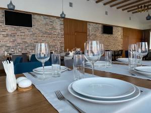 a table with plates and wine glasses on it at Darino in Rodnikovka