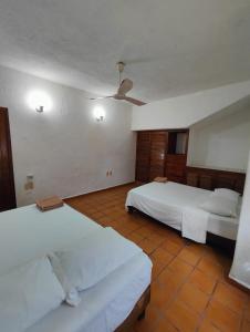 a bedroom with two beds and a ceiling fan at Villa Isabel 2 in Tangolunda