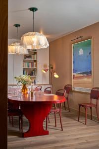 uma sala de jantar com uma mesa vermelha e cadeiras em Hôtel de La Boétie em Paris