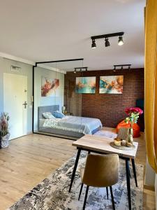ein Wohnzimmer mit einem Bett und einem Tisch in der Unterkunft Apartamenty 1-maja 94 in Kattowitz