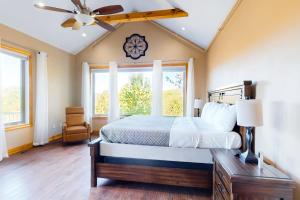 een slaapkamer met een bed en een plafondventilator bij Treetop View Sanctuary in Branson