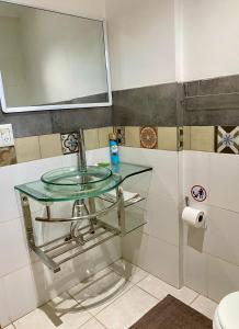 a glass sink in a bathroom with a mirror at Santino Apart in Puerto Iguazú +66 photos
