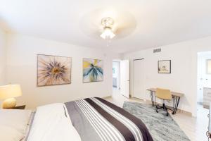 Un dormitorio blanco con una cama y un escritorio. en Starfish Wishes, en Riviera Beach