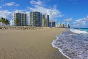 Una playa con edificios altos y el océano. en Starfish Wishes, en Riviera Beach