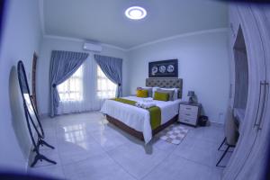 哈博罗内KAY'S TWO-BED SELFCATERING APARTMENT@21211的卧室里有一张大床，上面有黄色枕头