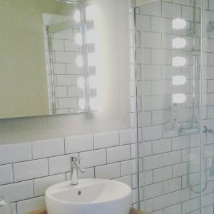 een witte badkamer met een wastafel en een spiegel bij Casa de los deseos 