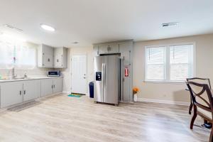 a kitchen with a stainless steel refrigerator and white cabinets at Easy Keel in Charleston