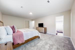 a white bedroom with a bed and a tv at Easy Keel in Charleston