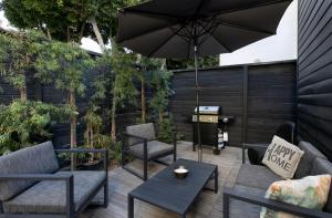 patio con sedie, tavolo e ombrellone di ArtSpace Venice Beach Bungalow at Best Location a Los Angeles