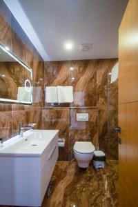 a bathroom with a sink and a toilet at NBT Hotel Lac in Laç