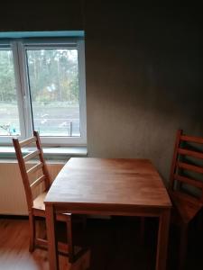 a wooden table and two chairs in front of a window at Weidmannsruh Apartment für 2 bis 3 Personen in Frauendorf