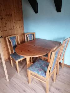 a wooden table and chairs with a wooden table and chairs at Weidmannsruh Apartment für 2 bis 3 Personen in Frauendorf