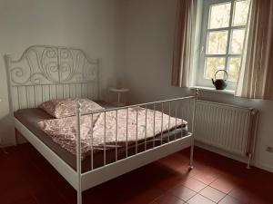 ein weißes Bett in einem Schlafzimmer mit einem Fenster in der Unterkunft Vesta Waldhaus Bardowicker Heide in Bardowick