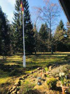einen Garten mit einer Fahnenstange auf einem Feld in der Unterkunft Vesta Waldhaus Bardowicker Heide in Bardowick