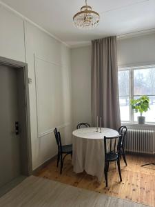 a dining room with a table and chairs and a window at Pastors Prästgården in Norberg