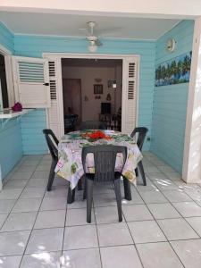 un tavolo e sedie su un patio in una casa di T2 cosy, spacieux et confortable a Les Trois-Îlets