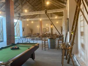 a pool table in a room with tables and chairs at Agroturystyka Smulsko in Przykona