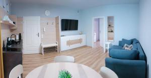 a living room with a blue couch and a table at Apartament Olchowa Prestige 1 in Ustroń
