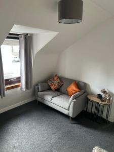 a living room with a couch and a window at The Loft, Inverness in Inverness