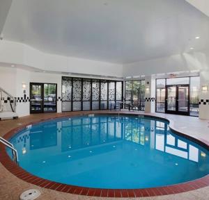 - une grande piscine d'eau bleue dans un bâtiment dans l'établissement DoubleTree Suites by Hilton Bentonville, à Bentonville