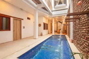 an indoor swimming pool in a house with a brick wall at Hotel Boutique de playa - Casa Solhu in Santa Marta