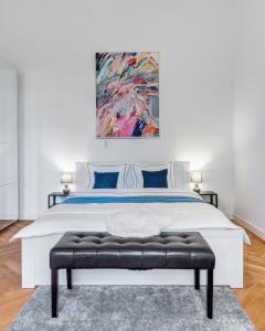 ein Schlafzimmer mit einem großen weißen Bett und einem Gemälde in der Unterkunft Szondi Residence in Budapest