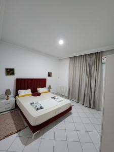 a bedroom with a large bed and a window at Duplex bien equipe securise avec jardin et veranda in La Marsa