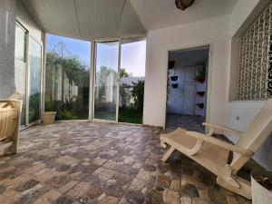 an empty room with a bench and large windows at Duplex bien equipe securise avec jardin et veranda in La Marsa