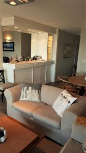 uma sala de estar com um sofá e uma cozinha em FULLY RENOVATED APT BY THE OCEAN em Punta del Este