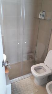 a bathroom with a toilet and a glass shower at FULLY RENOVATED APT BY THE OCEAN in Punta del Este