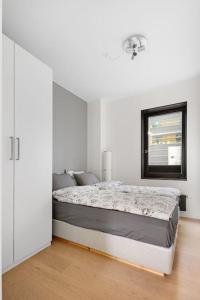 a white bedroom with a bed and a mirror at Modern 3bed room sea view apartment @ Oslo Barcode in Oslo