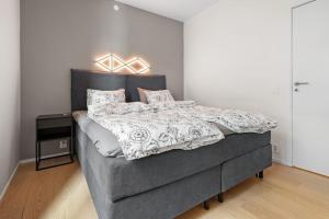 a bedroom with a large bed with a gray headboard at Modern 3bed room sea view apartment @ Oslo Barcode in Oslo +31 photos