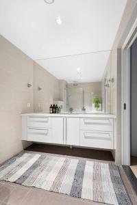 a white bathroom with a sink and a mirror at Modern 3bed room sea view apartment @ Oslo Barcode in Oslo