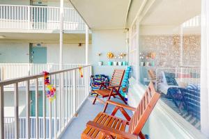 a balcony with two wooden chairs and a mural at Delights in Daytona Unit 525 in Daytona Beach