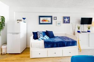 a bedroom with a white bed with blue sheets at Delights in Daytona Unit 525 in Daytona Beach