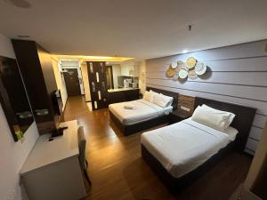a hotel room with two beds and a kitchen at Sweet Studio Apartment in Kota Bharu