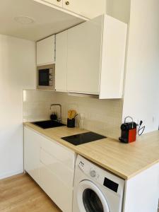 een keuken met witte kasten en een wasmachine bij Appartement Chaleureux en Hyper Centre à Lille in Lille