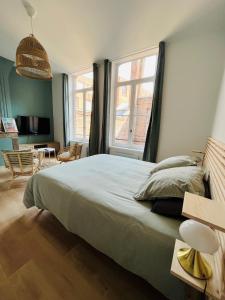 een slaapkamer met een groot bed en 2 ramen bij Appartement Chaleureux en Hyper Centre à Lille in Lille