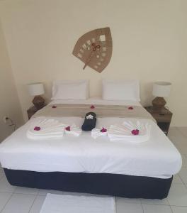 a bedroom with a bed with towels on it at Wolfgramm Beachfront Motel in Utungake