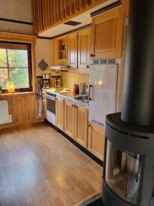 cocina con nevera blanca y fogones en Cozy mountain house in Jämtland en Vallrun
