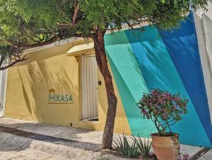 un edificio colorato con un albero di fronte di 2BR -Water at Mikasa- Fast WIFI, King beds, AC, Near beach, Pool a Puerto Escondido