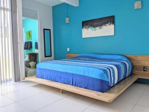 una camera blu con un letto con struttura in legno di 2BR -Water at Mikasa- Fast WIFI, King beds, AC, Near beach, Pool a Puerto Escondido