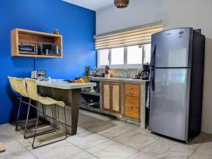 una cucina con frigorifero in acciaio inossidabile e mobili in legno di 2BR -Water at Mikasa- Fast WIFI, King beds, AC, Near beach, Pool a Puerto Escondido