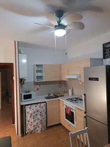 uma cozinha com uma ventoinha de tecto e um frigorífico em la casina accogliente em Pisa