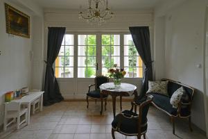 d'un salon avec une table, des chaises et une fenêtre. dans l'établissement Siófok Villa, à Siófok